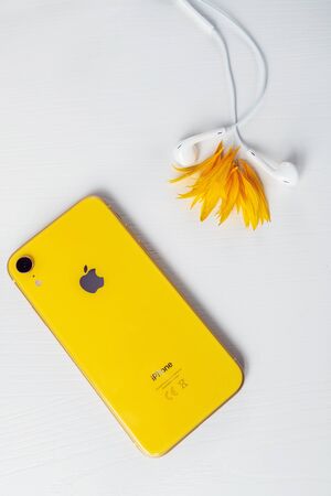 12.08.2019 Ukraine: yellow iphone xr and headphone on isolated backgroundのeditorial素材