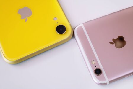 22.08.2019 Ukraine: Closeup yellow iphone xr and pink iphone 6s on isolated backgroundのeditorial素材