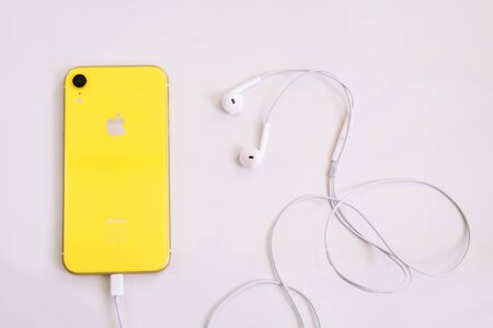 8.20.2019 - Kyiv, Ukraine: Yellow iphone XR with headphoneのeditorial素材