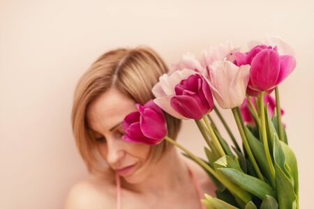 Woman with a bouquet of tulips at spring timeの写真素材
