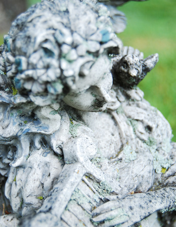 This is an old statue withered with time of an angel playing a harp.の写真素材