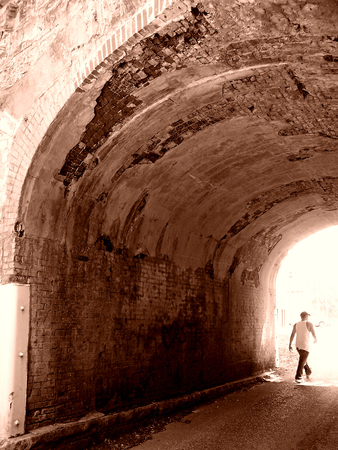 This old bridge hung over a single lane street where people seldom walked.の写真素材