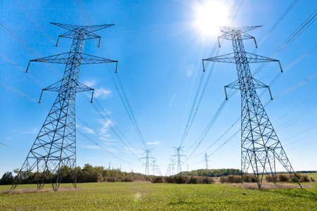 Hydro towers run off into the distance through the countryside  Shot against a blu sky on a sunny...