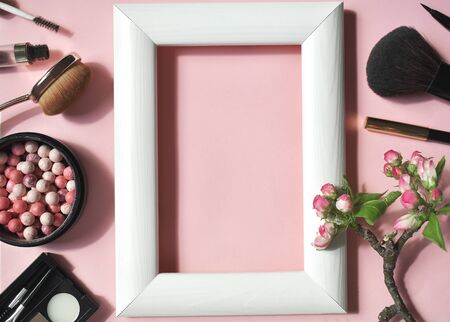 A set of decorative cosmetics on a pink background with a white frame in the center. Top viev. Flat lay.の写真素材