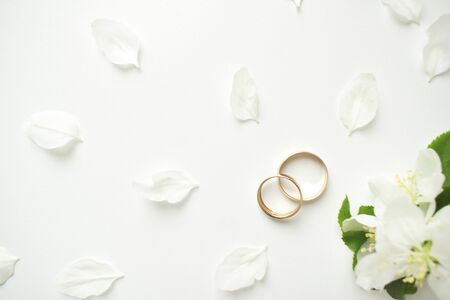 Wedding ring. On a white background and with delicate white flowers. Wedding symbols and attributesの写真素材