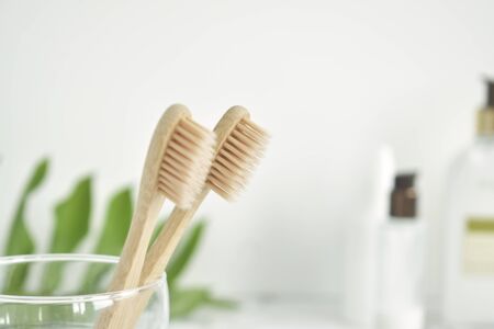 Bamboo toothbrushes are eco-friendly in a glass with a copy of the space on a white background. Zero waste. Free plastic. Top view.の写真素材