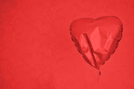 Red heart balloon on red background. Space for text.の写真素材