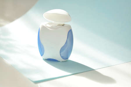Dental floss on a blue background. Copyspace, topview.