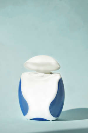 Dental floss on a blue background. Copyspace, topview.