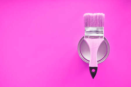 One open can of white paint with a brush, on a bright background. The view from the top. The concept of renovation.の写真素材