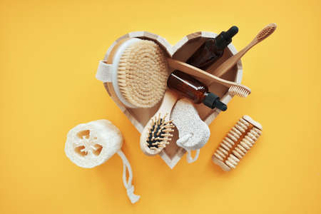 Zero waste. Bathroom accessories, natural brush, wooden comb, oil, makeup remover in a glass...