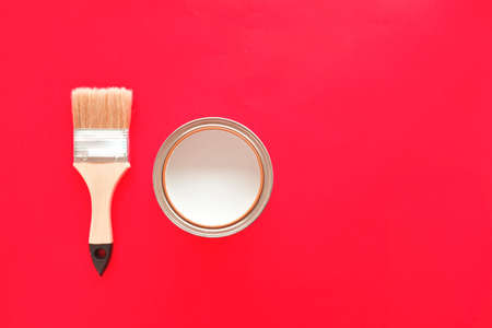 One open can of white paint with a brush, on a bright background. The view from the top. The concept of renovation. Copy space.の写真素材