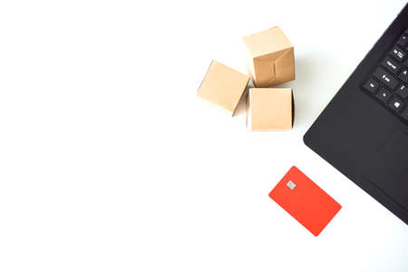 Online store. Purchase online. Paper boxes and credit cards in hand near the laptop. An online shopping service that offers home delivery.の写真素材