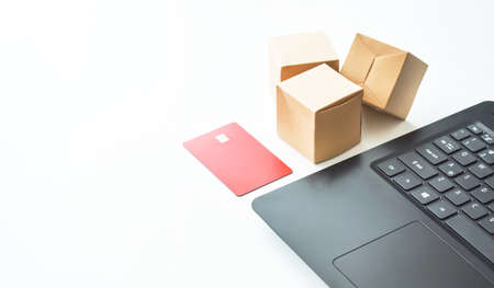 Online store. Purchase online. Paper boxes and credit cards in hand near the laptop. An online shopping service that offers home delivery.の写真素材