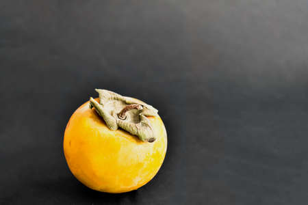 Ripe persimmon on a black table. Top view.の写真素材