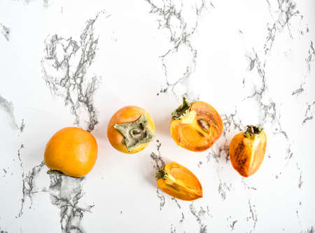 Ripe persimmon on the marble countertop. Top view.の写真素材