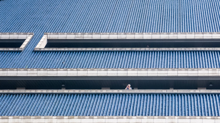 Man takes photos among blue roof tiles of Hubei Provincial Museumのeditorial素材