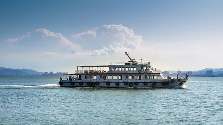 Passenger ferry crosses Weihai Harbor on a sunny dayのeditorial素材