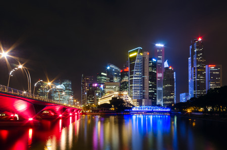 The view across the bay to the Singapore night bridge, skyscrapers and bright lightsの写真素材