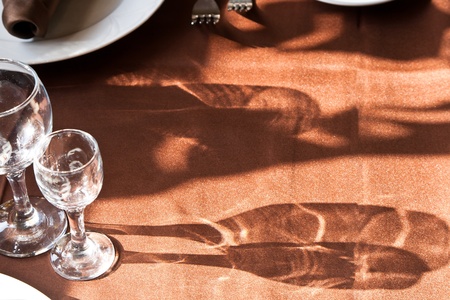 glass and plate on brown tableclothの写真素材