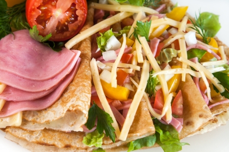 Rolled thin pancakes with ham, cheese and vegetablesの写真素材