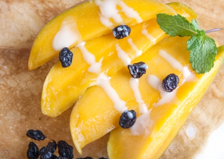 Rolled thin pancakes with mango and raisinsの写真素材