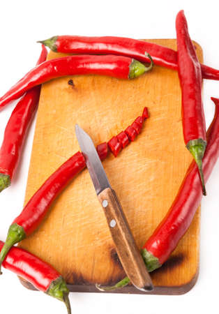 hot capsicum chili pepper and knife on wooden boardの写真素材