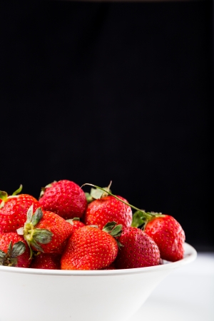 fresh strawberry in white plate on black backgroundの写真素材