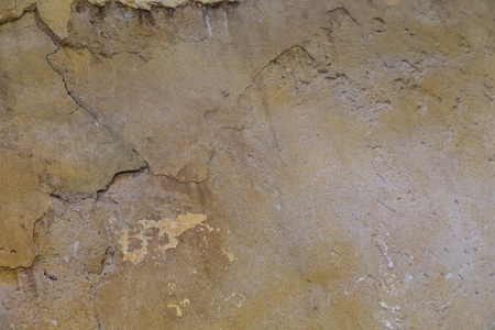 a damaged yellow stucco on wall indoors