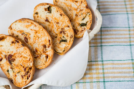 white sliced homemade baguette with dried tomatoes and herbs