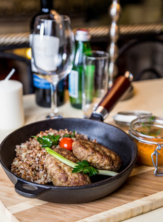 Restourant serving dish - cutlet with buckwheat on wooden boardの写真素材