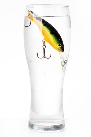 closeup fishing bait wobbler in glass with waterの写真素材