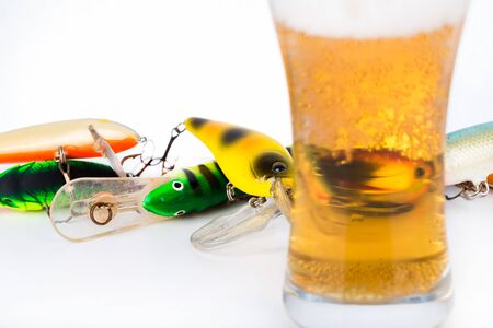 closeup fishing bait wobblers near glass with light beerの写真素材