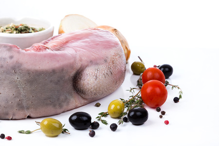 uncooked raw tongue with serving spices on white backgroundの写真素材