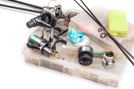 different fishing tackles - rod, reel, line and lures in box on white backgroundの写真素材