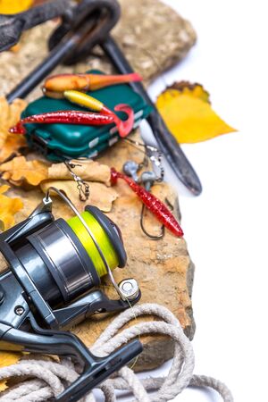 fishing tackles on stones with anchor and leafs on white backgroundの写真素材