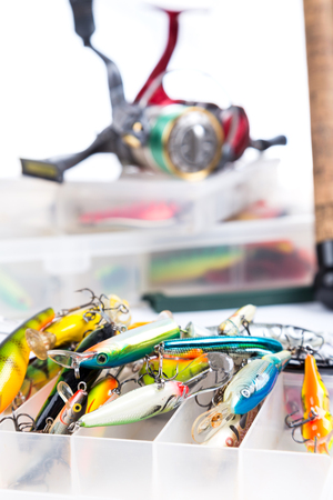 fishing tackles, fishing lure and fishing bait on plastic storage boxes on bright white background. for design advertising or publicationの写真素材
