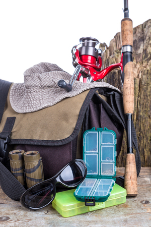 fishing tackles with handbag and hat on wooden background. for design advertising or publicationの写真素材