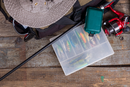 fishing tackles with handbag and hat on wooden background. for design advertising or publicationの写真素材
