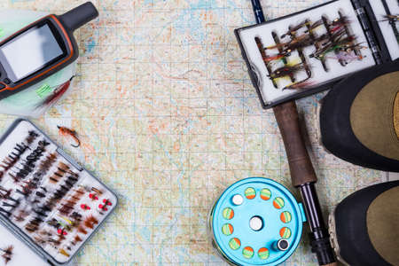 inted to fishing journey with fishing tackles and waterproof shoes on paper map backgroundの写真素材