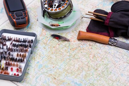 intend to fishing journey with fishing tackles and gps navigator on paper map backgroundの写真素材