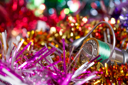christmas and new year a postcard for fishers and anglers. fishing reel on bright spangles and ball...