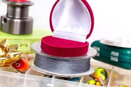 valentines day fishing surprise present - open red box of heart on tackles storage with baits and...
