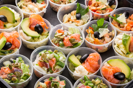 closeup set different canapes and snacks in plastic black form for mobile cateringの写真素材