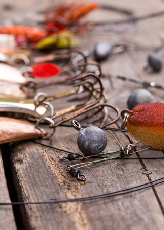 different fishing tackles and spoon on wooden board background. Concept design for freshwater outdoor active business company.の写真素材