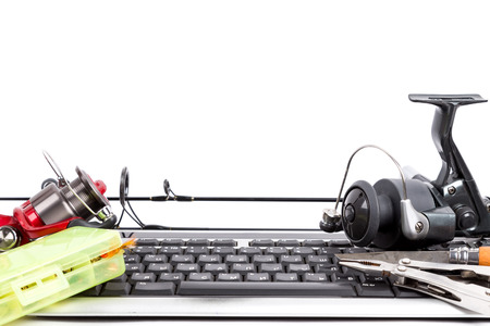 different fishing tackles on computer keyboard with white background. Concept design for freshwater outdoor active business company, on-line shopping, forumsの写真素材