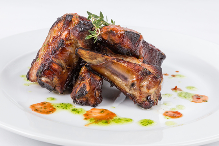 portion hot smoked barbecue ribs on white plate serving in restaurantの写真素材