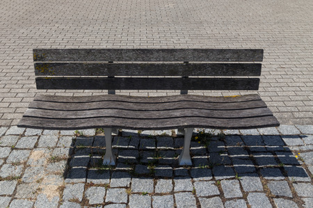 empty wooden bench on street in summer day