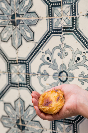 Traditional Portuguese egg tart pasty cake dessert Pasteis de nata in women hand. On background...