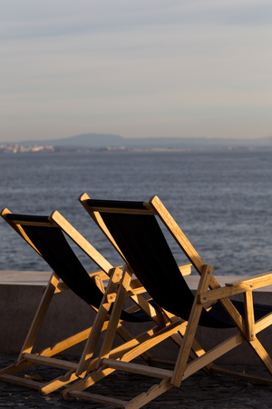 chaser longue on waterfront of a river in evening sunset lightの写真素材
